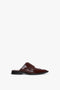 Side view of a Flat Lace Up Mules In Bordeaux Leather by Victoria Beckham, crafted from fine calfskin leather, with a slip-on design and a black sole against a white background.