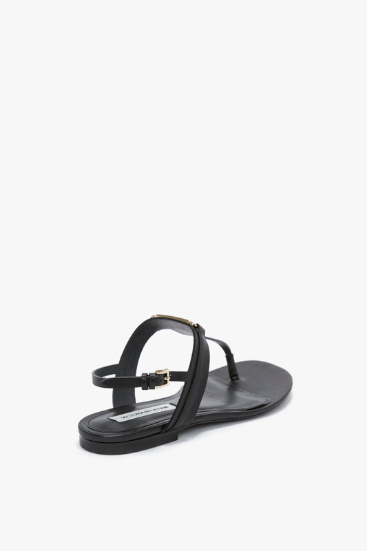 A black flat sandal with thin straps, a small buckle on the ankle strap, and crafted from luxurious calfskin leather. This Flat Chain Sandal In Black Leather by Victoria Beckham is part of the stylish SS24 collection.