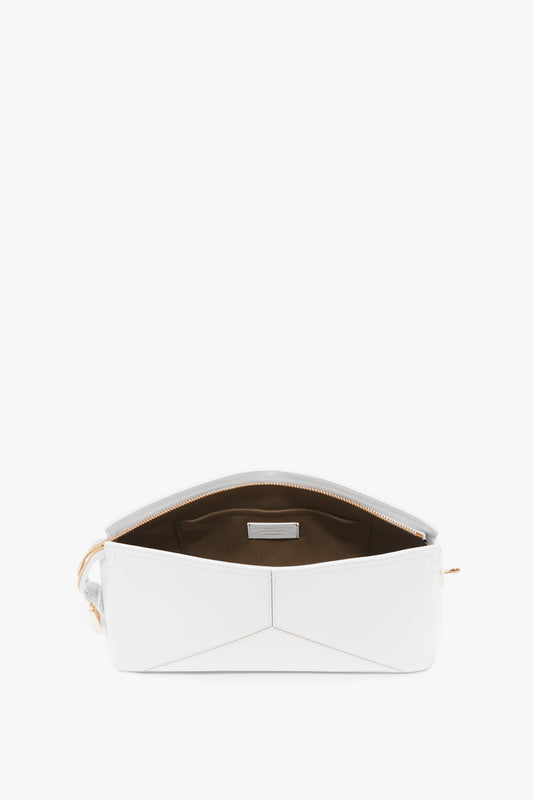 An open Victoria Beckham Exclusive Victoria Clutch Bag In White Leather with a brown interior and gold zipper, featuring a structured design that showcases the clean lining and spacious inside.