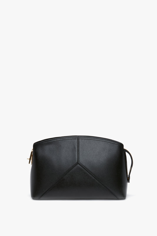 Victoria Beckham's Victoria Clutch Bag In Black Leather features a geometric design on the front and a zip closure on top, presenting a structured silhouette for an elegant touch.