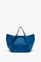 A vibrant blue leather tote bag with a structured design, featuring double handles and a minimalist appearance. This W11 Medium Tote Bag In Vibrant Blue by Victoria Beckham is crafted from grained leather for added texture and durability.