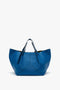 A W11 Medium Tote Bag In Vibrant Blue by Victoria Beckham, featuring a structured design, dual handles, and a minimalist appearance.