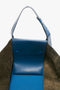 A W11 Medium Tote Bag In Vibrant Blue with metal accents made from grained leather, featuring the embossed text "Victoria Beckham" and "Made in Italy" on the inside flap.