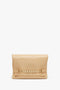 Beige leather Chain Pouch Bag With Strap In Sesame Leather by Victoria Beckham featuring a rectangular shape and a woven strap detail across the front with an elegant gold chain detail, displayed against a white background.