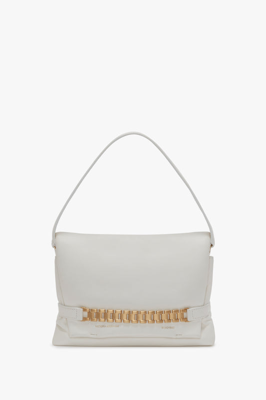 A Puffy Chain Pouch With Strap In White Leather by Victoria Beckham, featuring a single shoulder strap and a minimalist design, reminiscent of Victoria's vintage watch straps.