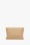 A neutral-colored, rectangular Chain Pouch Bag With Strap In Sesame Leather by Victoria Beckham with a gold chain detail is positioned against a white background.