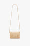 A Mini Chain Pouch With Long Strap In Sesame Leather by Victoria Beckham, set against a plain white background.