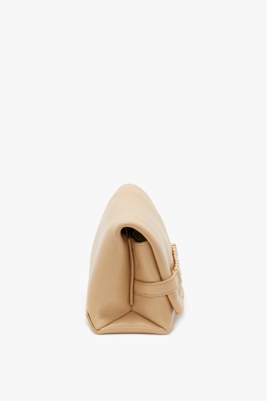 A Mini Pouch with Long Strap in Sesame Leather by Victoria Beckham positioned on its side, partially open, against a white background.