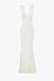 A Gathered Shoulder Floor-Length Cami Gown In Ivory from Victoria Beckham. The crepe back satin dress boasts a fitted bodice that flares slightly at the hem.