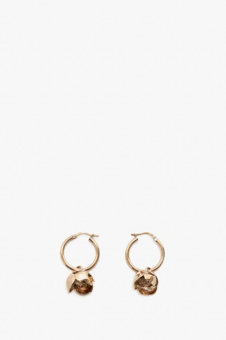 A pair of Exclusive Camellia Flower Hoop Earrings in Gold with attached rough-cut gemstones, displayed against a plain white background by Victoria Beckham.
