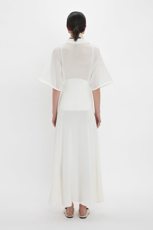 A person wearing a Victoria Beckham Panelled Knit Dress In White with short sleeves, standing and facing away from the camera against a plain white background.