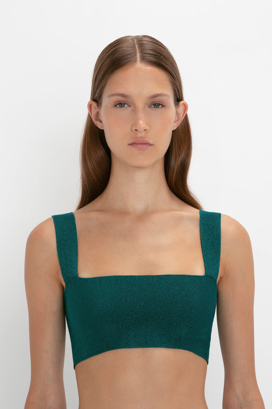 A woman with long hair wearing a VB Body Strap Bandeau Top In Lurex Green and a VB Body Flared Skirt stands against a plain, white background.