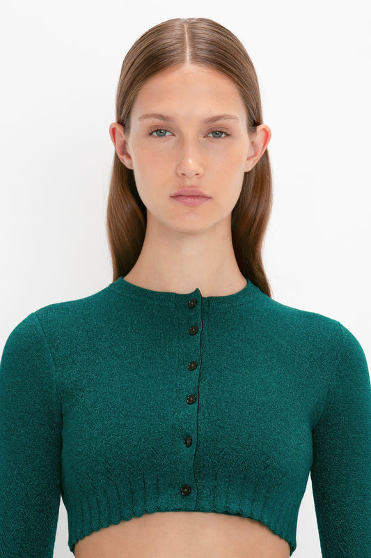 Person with straight, brown hair, wearing a Victoria Beckham VB Body Cropped Cardi In Lurex Green, posed against a plain white background.