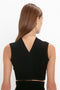 A person with long brown hair is shown from behind, wearing a sleeveless black top with a V-shaped back – the Victoria Beckham VB Body Scallop Trim Tank Top In Black, a versatile tank top that's a true summer essential.