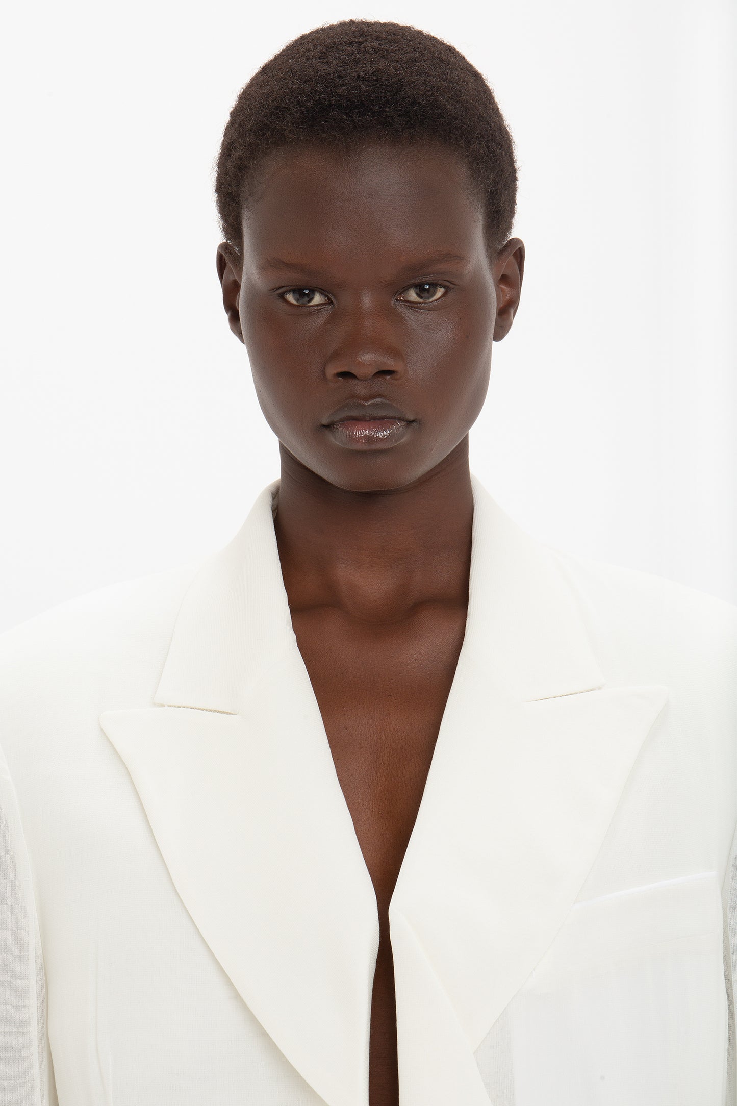 Person with short hair wearing the Fold Detail Tailored Jacket In White by Victoria Beckham, facing the camera against a plain white background.