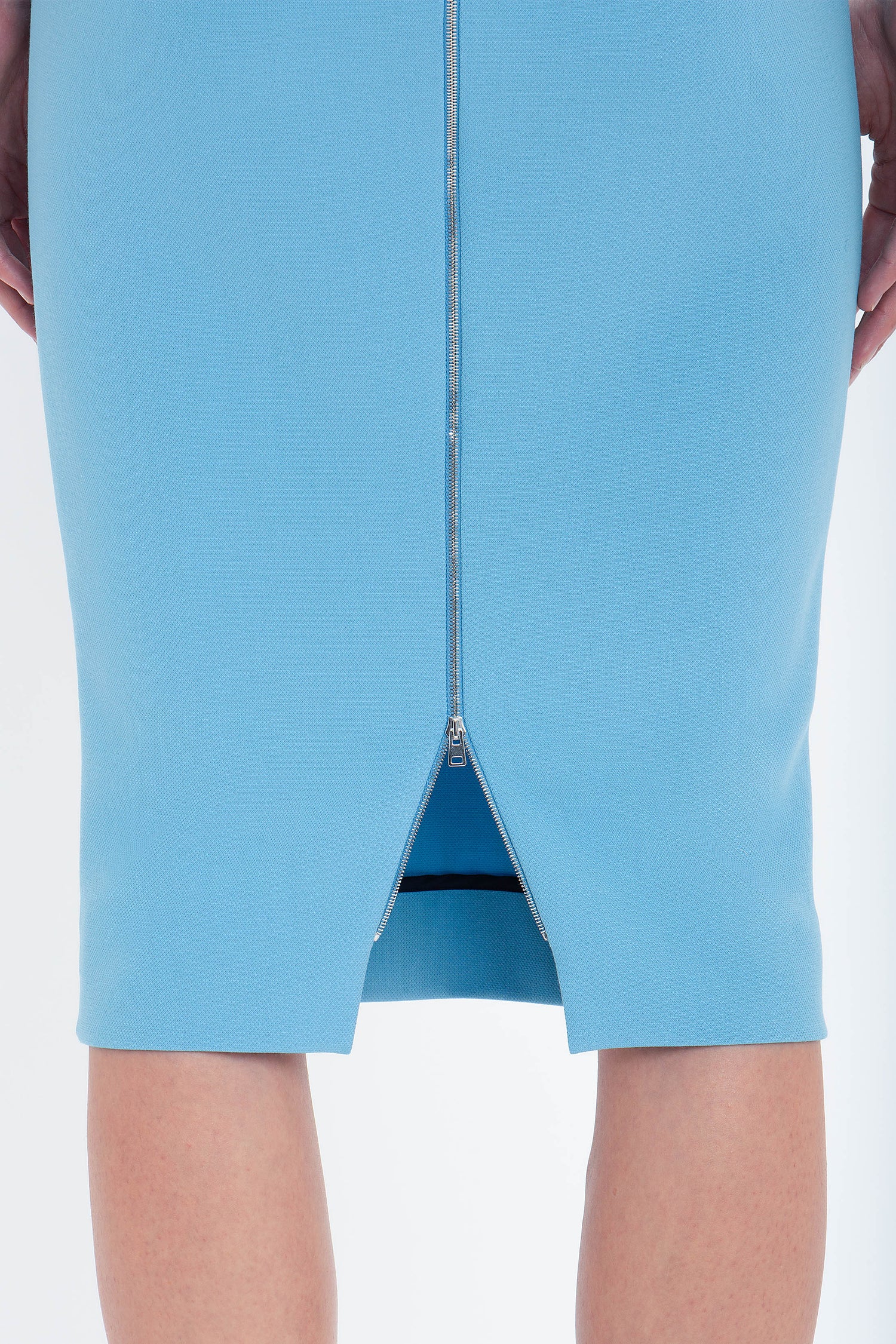 Close-up view of a Victoria Beckham Exclusive Fitted T-Shirt Dress In Periwinkle Blue with a full-length back zipper, worn by a woman, showing the lower back down to the knees.
