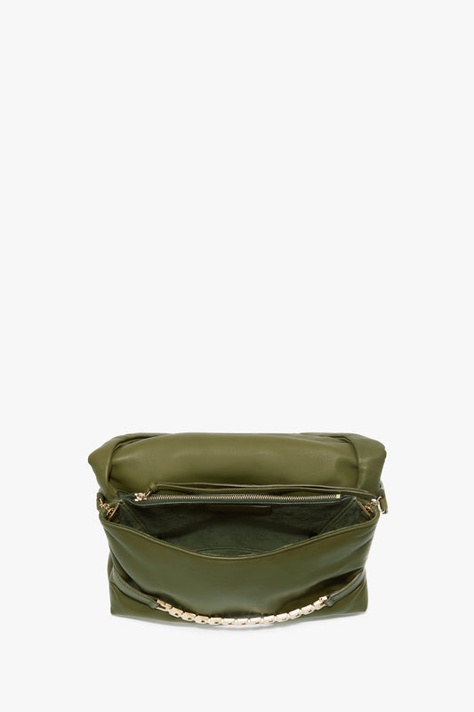 A Puffy Chain Pouch With Strap In Khaki Leather by Victoria Beckham with a partially unzipped main compartment, displaying a puffy chain pouch detail on the front.