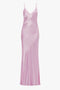 A floor-length, sleeveless Low Back Cami Floor-Length Dress in light pink satin with thin shoulder straps and a V-neckline, reminiscent of Victoria Beckham's chic style.