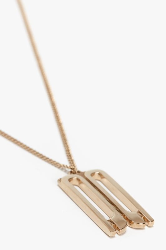 An Exclusive Frame Necklace In Gold with a long, thin chain featuring a geometric, double-bar pendant and the Victoria Beckham logo.