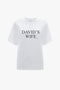 Victoria Beckham's 'David's Wife' Slogan T-Shirt in White, made of organic cotton and featuring the phrase printed in black letters on the front, displayed on a plain background.