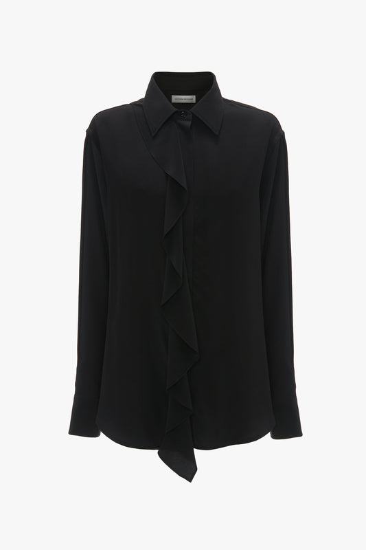 Victoria Beckham's Asymmetric Ruffle Blouse In Black, with long sleeves and a classic collar, is displayed on a plain white background.