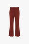 A pair of Wide Cropped Flare Trouser In Russet by Victoria Beckham, with a fitted waistband and front pockets, displayed against a white background.