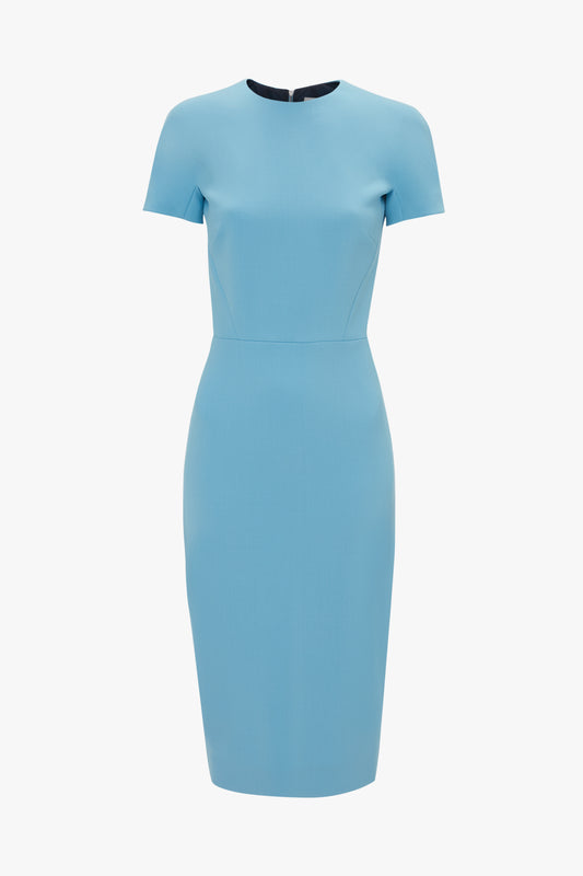 The Victoria Beckham Exclusive Fitted T-Shirt Dress In Periwinkle Blue is a knee-length, short-sleeved dress with a fitted silhouette. It has a round neckline and a seam at the waist. The back is fastened with an exposed metal zip.