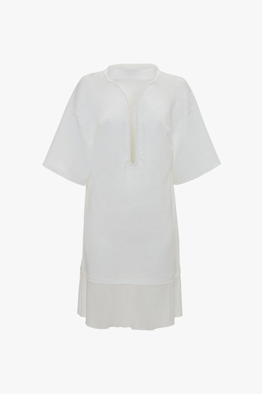 A white Victoria Beckham Frame Cut-Out T-Shirt Dress In White, with a keyhole neckline, front slit, and pleated hem.