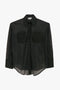 A lightweight semi-sheer black long-sleeve button-up shirt with tailored design details, featuring two chest pockets and cuffs: the "Pocket Detail Shirt In Black" by Victoria Beckham.