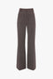 A pair of high-waisted Victoria Beckham Alina Trousers in Tobacco with a subtle checkered pattern, featuring front pockets and a zip fly.