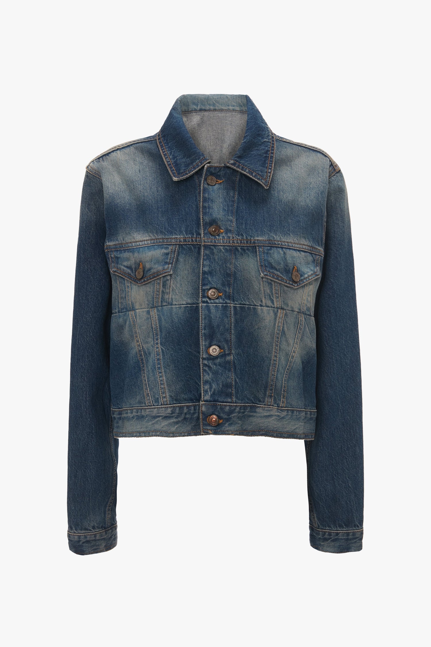 A front view of the Cropped Denim Jacket In Heavy Vintage Indigo Wash with buttons. Designed by Victoria Beckham, this blue denim jacket features long sleeves and two chest pockets.