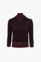 A dark burgundy, long-sleeved Merino wool knit sweater with a V-neckline and a ribbed hem displayed on a mannequin is the **Double Layer Top In Deep Mahogany** by **Victoria Beckham**.