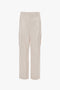 Relaxed Cargo Trouser In Bone by Victoria Beckham with multiple pockets and belt loops, made from 100% cotton and photographed against a plain white background.