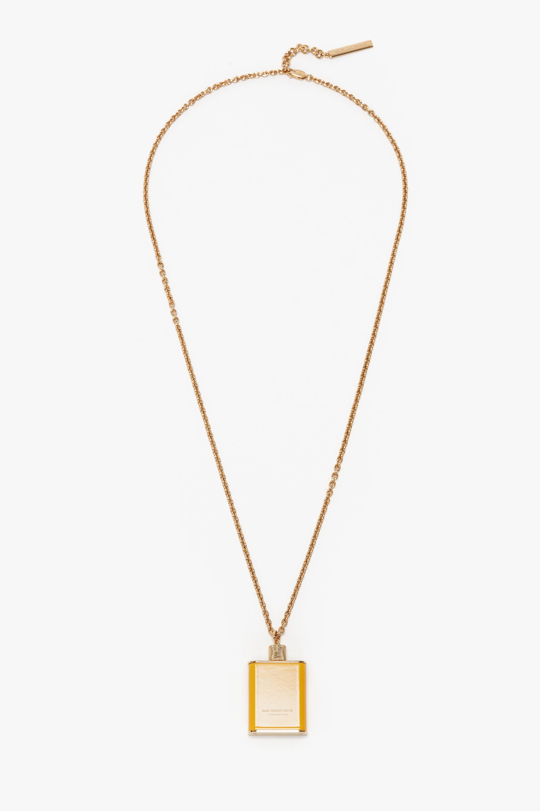 A gold brushed brass necklace featuring a rectangular pendant designed to resemble a perfume bottle, epitomizing unique jewellery with a touch of Victoria Beckham branding, the Perfume Bottle Necklace In San Ysidro Drive by Victoria Beckham.