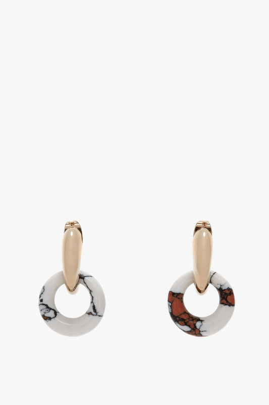 A stunning pair of Exclusive Resin Pendant Earrings In Light Gold-White from Victoria Beckham, featuring circular pendants with a white and brown marbled pattern, crafted in Italy from antiallergic stainless-steel.