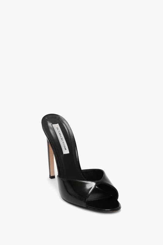 A Victoria Beckham Classic Mule In Black Calf Leather with an open toe, a seductive curved stiletto heel, and a sleek patent leather finish.