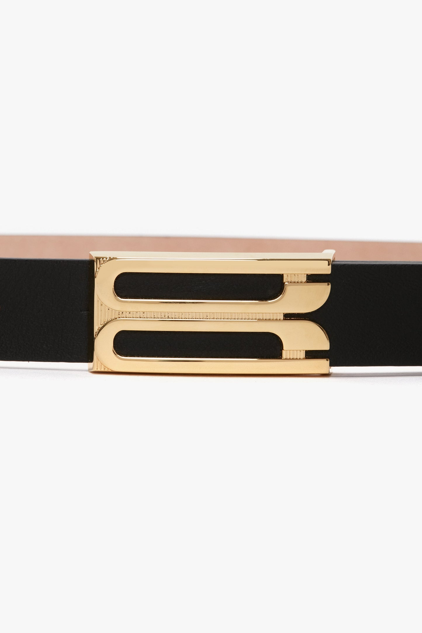 A fashion-forward Victoria Beckham Frame Belt In Black Leather with a gold rectangular frame buckle, featuring a split design, on a white background.