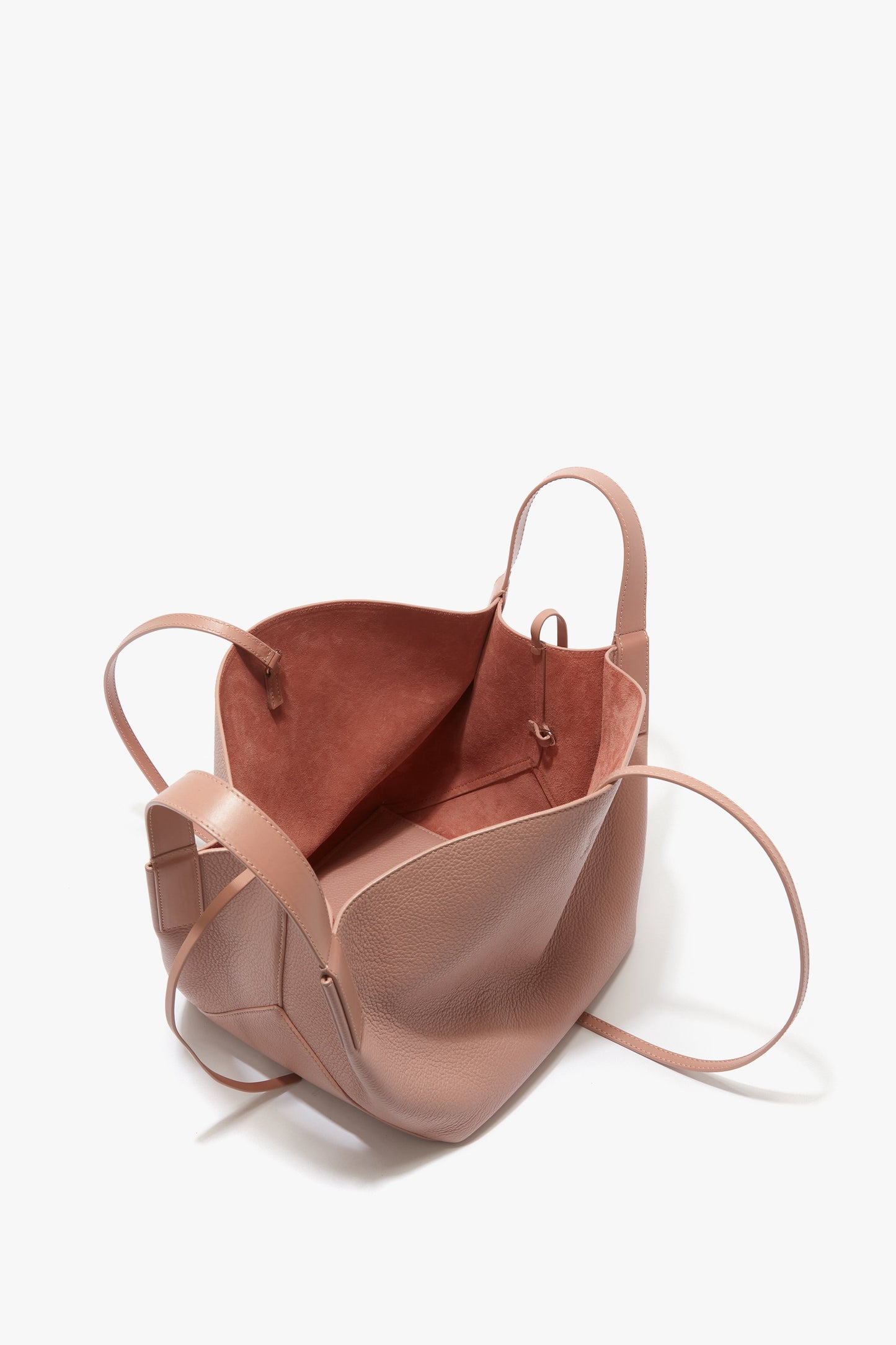Open, dusky pink [**Victoria Beckham W11 Mini Tote Bag In Marshmallow Leather**] with thin shoulder straps and a spacious interior, showing a suede-like inner lining and a small attachment loop.
