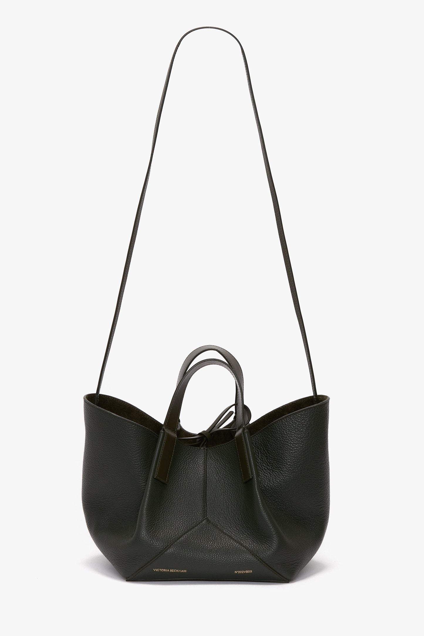 A black calf leather W11 Mini Tote Bag In Loden Leather by Victoria Beckham with long and short handles, featuring a minimalistic design and subtle branding at the bottom.