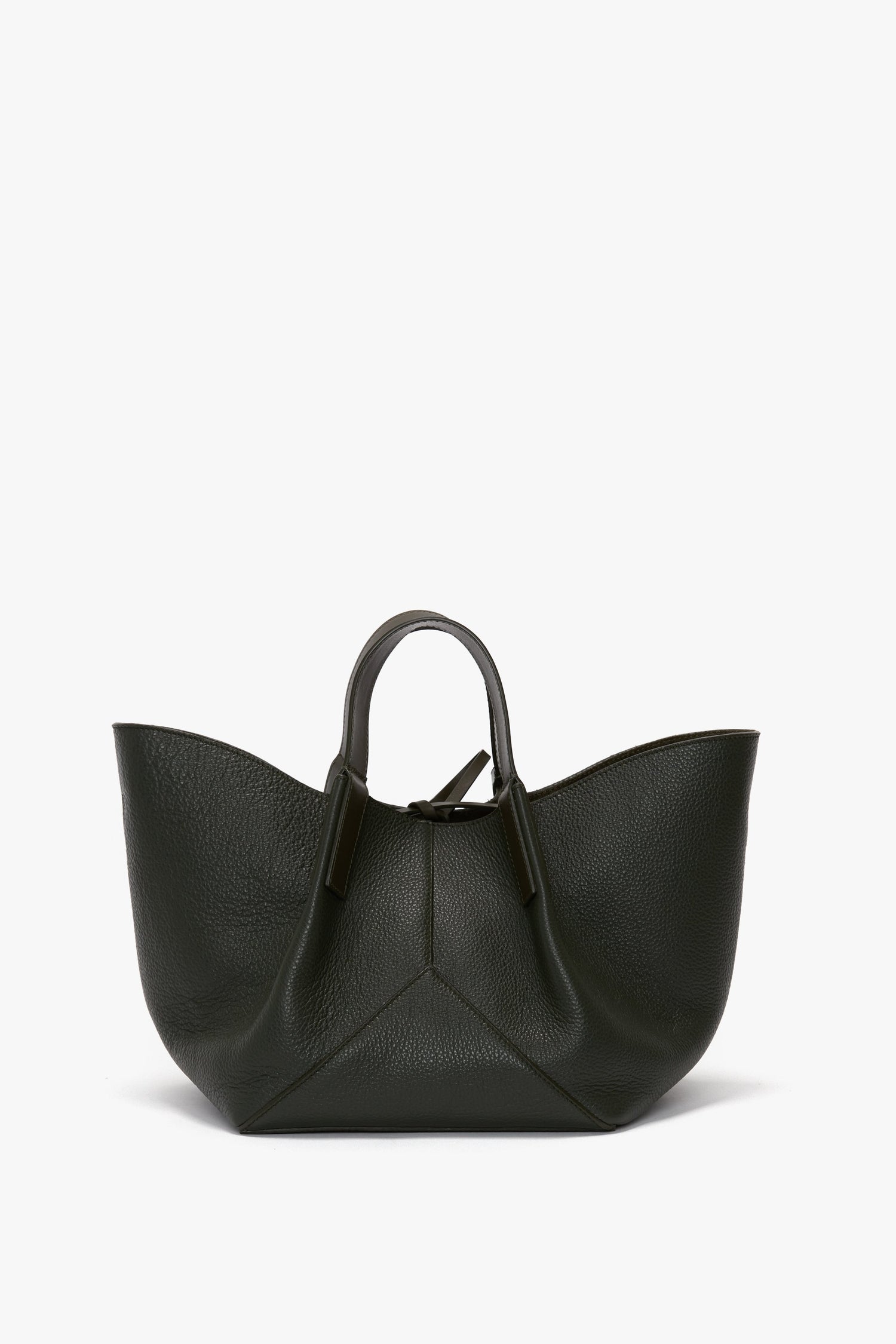 A dark green, calf leather tote bag with a textured surface, wide base, and short handles. The W11 Mini Tote Bag In Loden Leather by Victoria Beckham has a modern, angular design and is displayed against a plain white background.