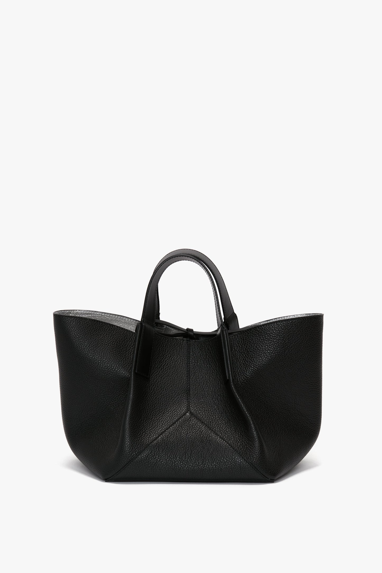 W11 Mini Tote Bag In Black Leather by Victoria Beckham, crafted from grainy calf leather, featuring two short handles and a structured, triangular shape that exudes luxurious sophistication.