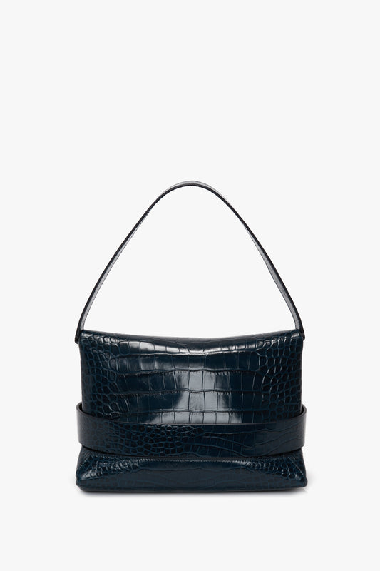 A B Pouch Bag In Croc Effect Midnight Blue Leather by Victoria Beckham with a short handle displayed on a plain white background.