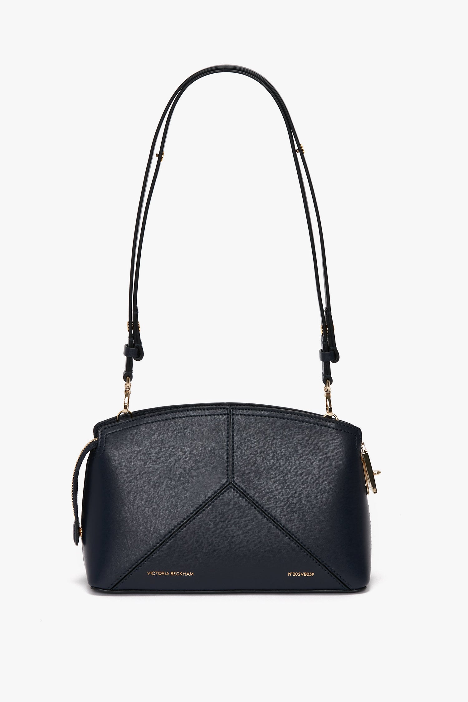 A sleek Exclusive Victoria Crossbody Bag In Navy Leather with gold accents, featuring an adjustable strap and a geometric design, perfect for those who appreciate quality leather goods.