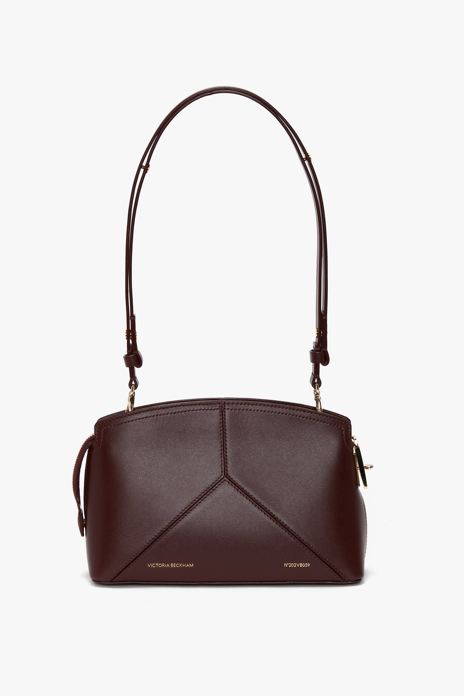 A dark brown textured calf leather handbag with a geometric design and gold-tone hardware, featuring the text "Victoria Beckham" and a padlock closure has been replaced by the Victoria Crossbody Bag In Burgundy Leather by Victoria Beckham.