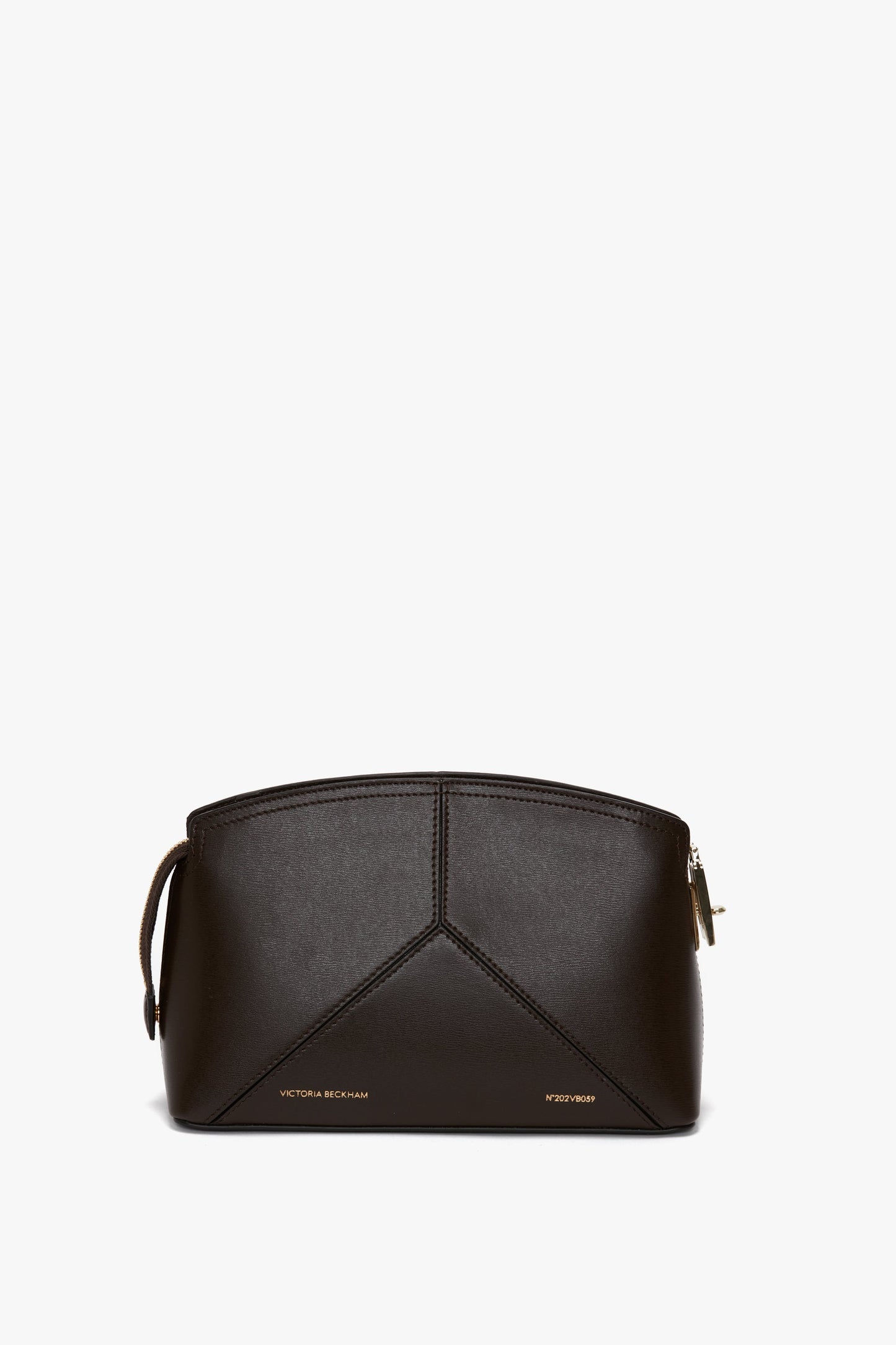 A brown leather crossbody bag with geometric stitching details, featuring a zip closure at the top and the signature V shape along with the words "Victoria Beckham Exclusive Victoria Crossbody Bag In Brown Leather" in gold at the bottom.