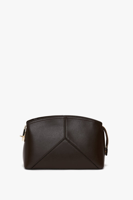 A small, dark brown calf leather Exclusive Victoria Crossbody Bag In Brown Leather by Victoria Beckham with a geometric design, featuring a zip closure and a small handle on one side, set against a plain white background.