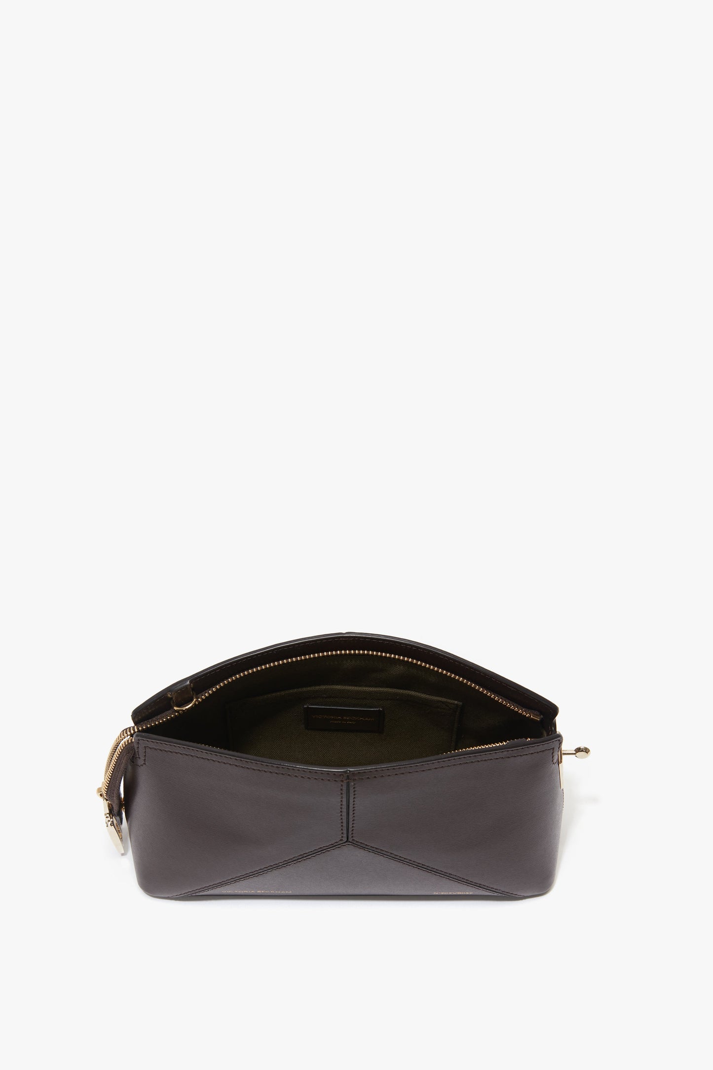 An open, dark brown Exclusive Victoria Crossbody Bag In Brown Leather by Victoria Beckham with a zippered main compartment, displaying interior pocket and lining, adorned with the signature V shape.