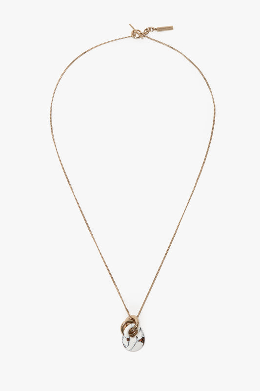 The Victoria Beckham Exclusive Resin Pendant Necklace In Light Gold-White features a chain-link pendant with a white and gray marble-like design, complete with a stylish T-bar closure.