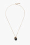 The Victoria Beckham Exclusive Resin Pendant Necklace In Light Gold-Black features a light gold chain with a black circular pendant and a small gold ring, elegantly completed with a T-bar closure.