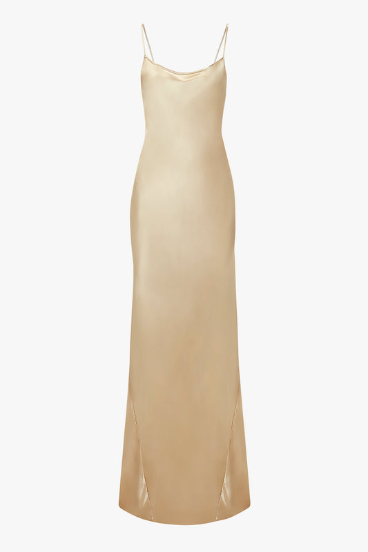A 1990s-inspired, long, gold satin camisole-slip dress with spaghetti straps and a slight flare at the bottom: Exclusive Floor-Length Cami Dress In Gold by Victoria Beckham.